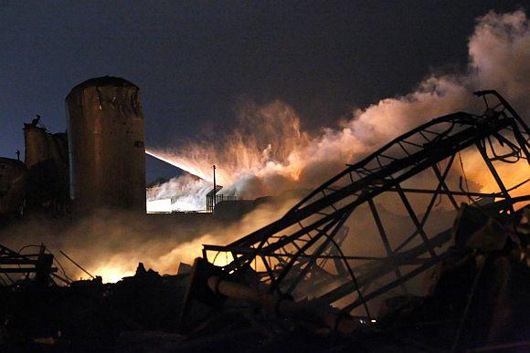 Smoke rises as water is sprayed at the burning remains of a fertilizer plant after an explosion at the plant in the town of West, near Waco, Texas