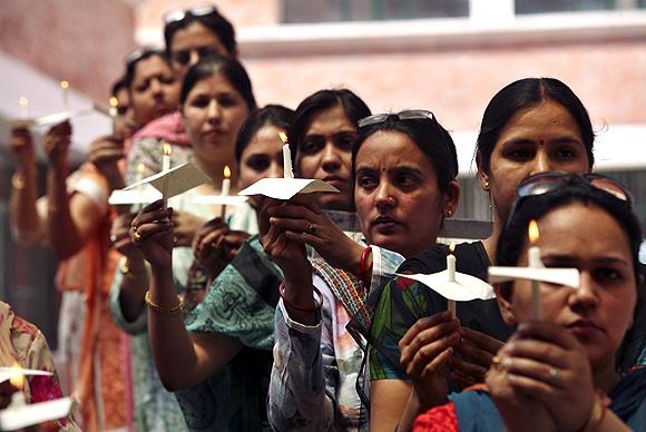 Demonstrators hold candles during a prayer meeting for the rape victim