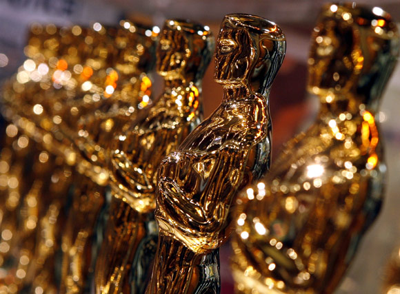 Oscar statuettes line up inside a glass case at a Meet the Oscars display in New York's Times Square