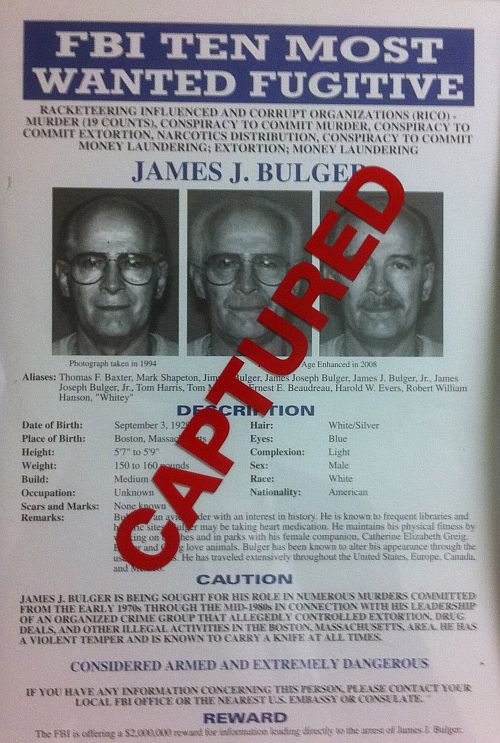 A most wanted poster for FBI Most Wanted fugitive and accused Boston crime boss James Whitey Bulger, is seen marked CAPTURED on a wall with other fugitive wanted posters at FBI headquarters in Washington