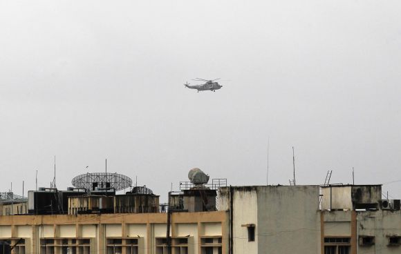 An Indian Navy helicopter flies over the naval dockyard in Mumbai 