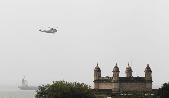 An Indian Navy helicopter flies over the naval dockyard in Mumbai on Wednesday