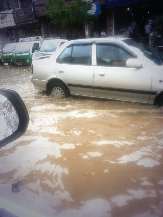 A car wades through a flooded Delhi street 