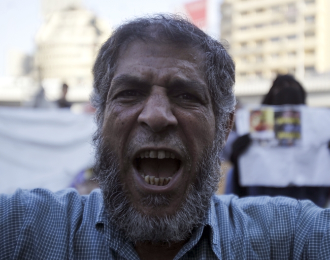  A supporter of the Muslim Brotherhood and Morsi shouts slogans against the military and interior ministry during a protest in front of Al Istkama mosque at Giza Square, south of Cairo