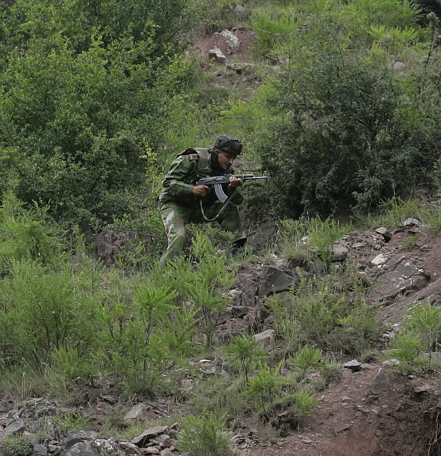 An Indian soldier runs near the Line of Control in Saraie, 150 km west of Srinagar