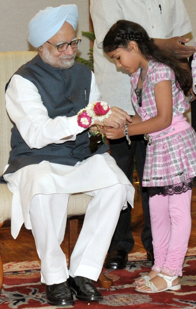 A schoolgirl ties a 'rakhi' to Dr Singh in New Delhi in August 2010