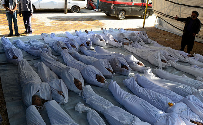 Syrian activists inspect the bodies of people they say were killed by nerve gas in the Ghouta region, in the Duma neighbourhood of Damascus