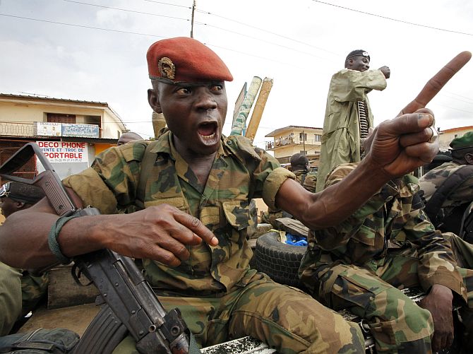A soldier of the Ivorian Army gestures during a patrol in Dabou