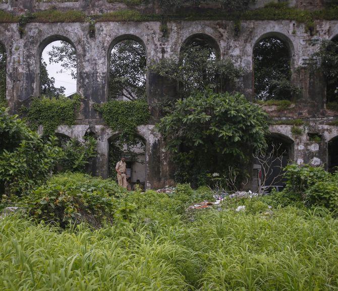 Policemen stand guard near the crime scene where a photo journalist was gang-raped inside an abandoned textile mill in Mumbai.