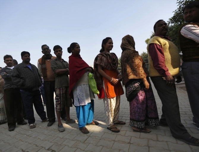 Voters line up in a queue outside a polling booth to cast their vote during the state assembly election in New Delhi 
