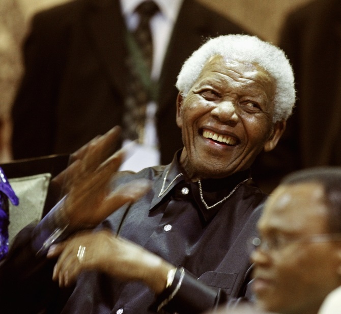 South Africa's former president Nelson Mandela gestures from the gallery at the opening of parliament in Cape Town February 11, 2010. 