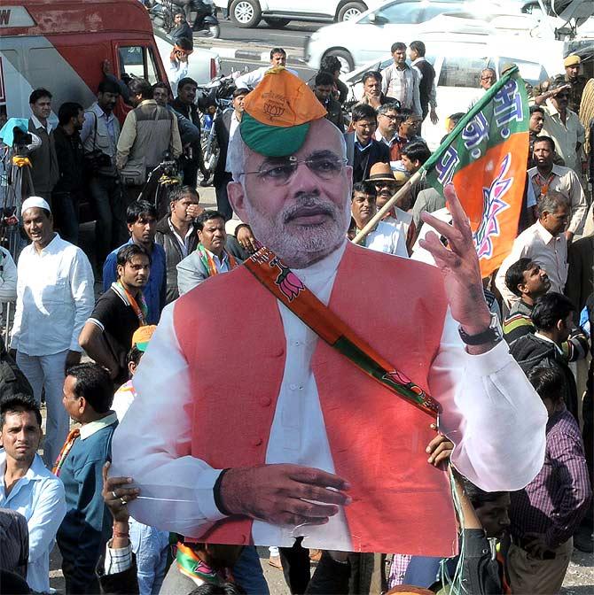 BJP supporters carry a cut out of their prime ministerial candidate Narendra Modi as they celebrate their thumping victory in Rajasthan.