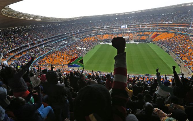People cheer as US President Barack Obama speaks at the First National Bank (FNB) Stadium, also known as Soccer City, during the national memorial service for Nelson Mandela in Johannesburg