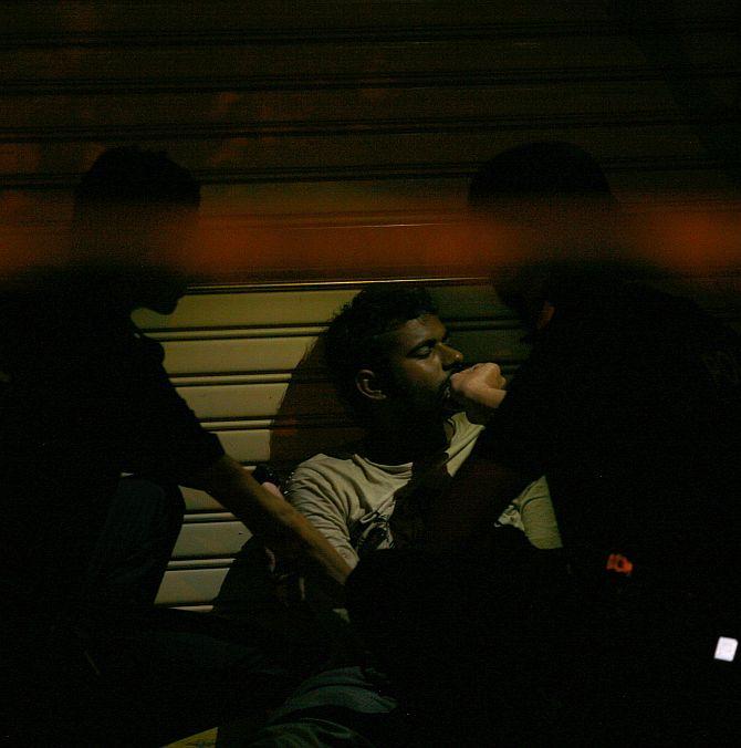 Police officers attend to a man in Singapore's Little India district following a riot