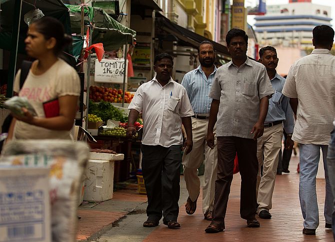Foreign workers walk around Little India
