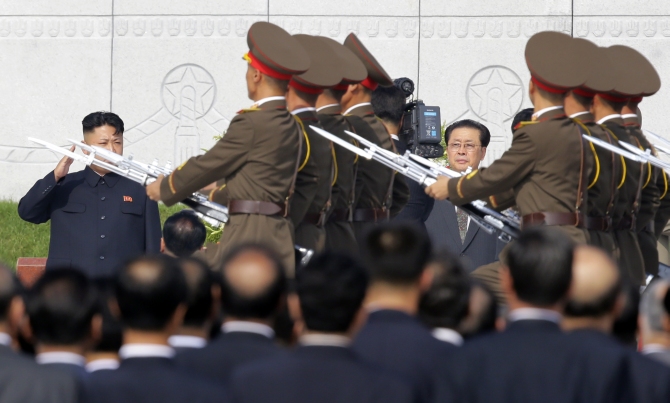 North Korean leader Kim Jong-un salutes to the members of the honour guards as he and Jang attend a commemoration event at the Cemetery of Fallen Fighters of the Korean People's Army in Pyongyang in this photograph taken on July 25, 2013.