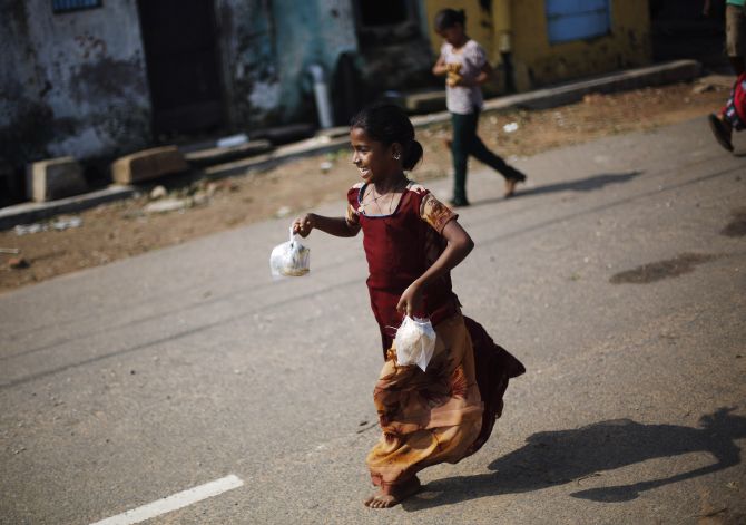 A girl runs home after receiving a free breakfast at the Cyclone Phailin-hit Gopalpur village, in Ganjam district of Odisha.