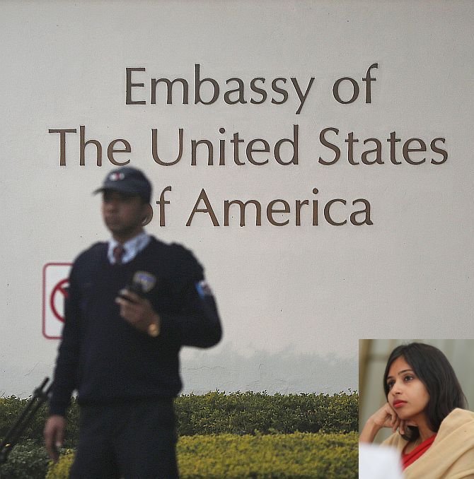 A US embassy security guard stands in front of the main gate of the embassy as the bulldozer (unseen) removes the security barriers, in New Delhi