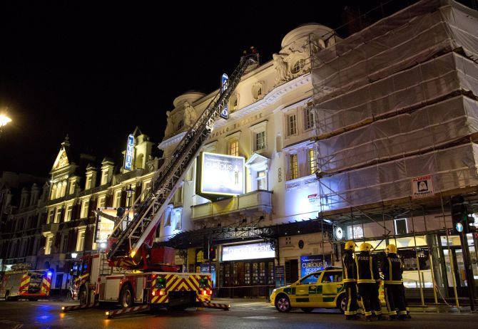 Emergency services look at the roof of the Apollo Theatre on Shaftesbury Avenue after part of the ceiling collapsed in central London 