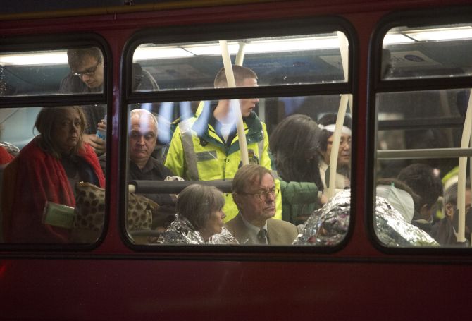 People receive medical attention on a bus after part of the ceiling at the Apollo Theatre on Shaftesbury Avenue collapsed in central London