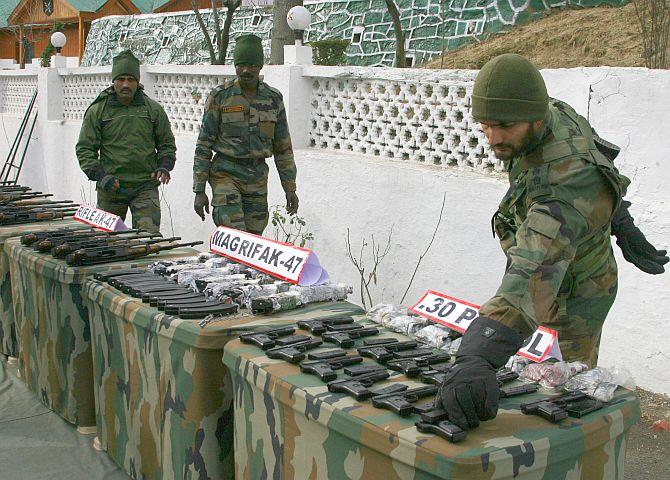 Army troopers showcase the seized weapons, in Srinagar on Sunday