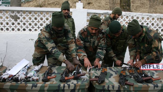 Army troopers showcase the seized weapons, in Srinagar on Sunday