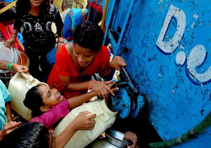 Households in Govindpuri slum fight over water from a Delhi Jal Board tanker that empties in minutes. The slum colony has no regular water supply or sanitation facilities