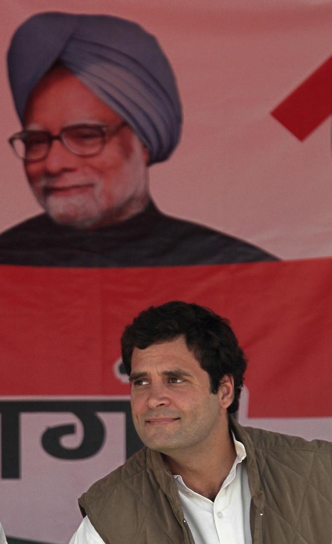 Rahul Gandhi sits under a poster of Prime Minister Manmohan Singh at a rally in Uttar Pradesh