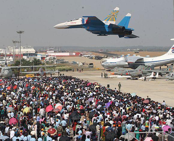 A jet, part of the Russian Knights aerobatic team, wows the audience at the Aero India 2013 in Bengaluru