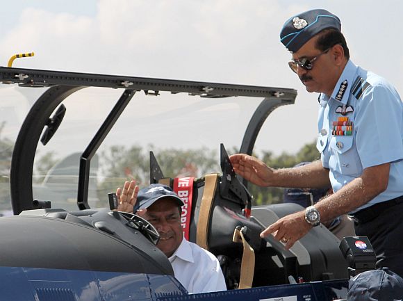 Defence Minister A K Antony in the cockpit of the Pilatus Trainer Aircraft at Aero India 2013. Alongside: Air Chief Marshal Norman Anil Kumar Browne.