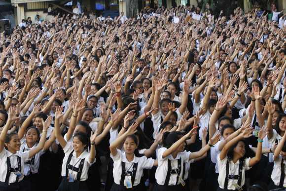 Thousands of students and faculty members dance to the theme song of the One Billion Rising campaign in the quadrangle of the St. Scholastica college in Manila