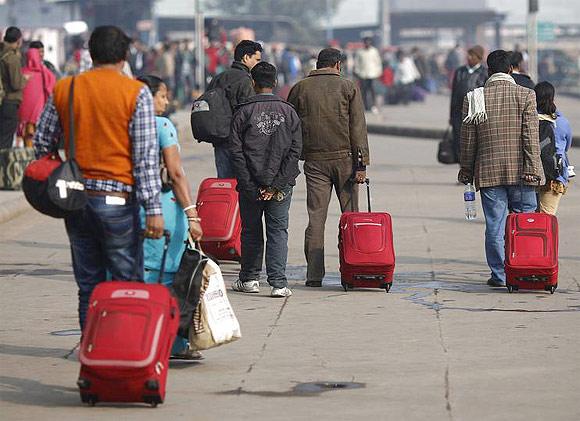 Commuters carry their luggage outside a railway station during the strike