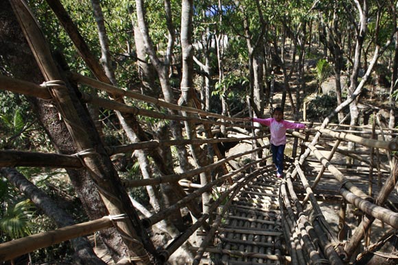 A bamboo staircase leads to a vantage point with a view of Bangladesh