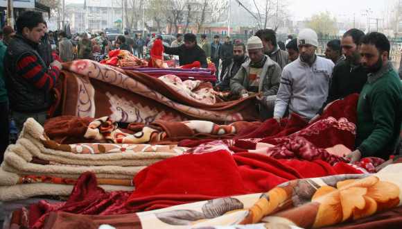 Locals buy blankets at a market in Srinagar