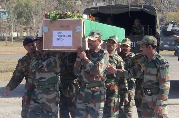 Indian Army soldiers carry a coffin containing the body of a colleague at a garrison in Rajouri district, about 170 km northwest of Jammu