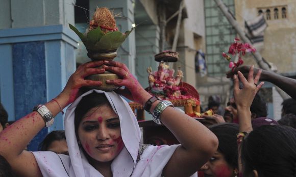A Hindu woman carries a coconut on her head as an offering for Lord Ganesh during Ganesh Chaturthi festival at the Laxmi Narain Temple in Karachi