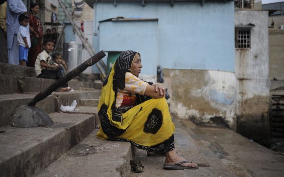 A woman sits alone while waiting for the celebrations on the first day of Ganesh Chaturthi at a temple in Karachi