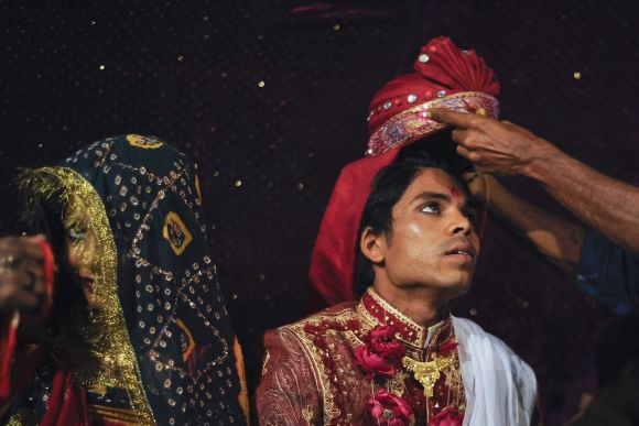 Sanjay wears a turban as he sits beside his wife Jasoda during a mass marriage ceremony in Karachi organised by the Pakistan Hindu Council