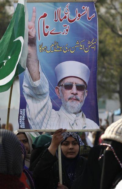 A supporter of Dr Tahir-ul Qadri holds poster during his speech in Islamabad on Wednesday