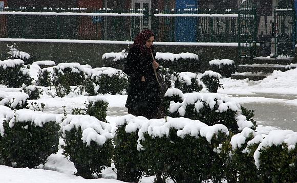 A girl walks on a snow covered pathway