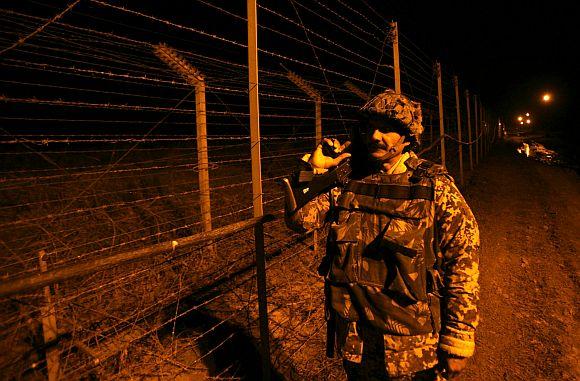 A Border Security Force trooper near the fenced border with Pakistan in Suchetgarh, Jammu and Kashmir