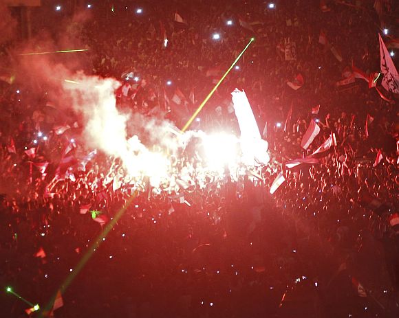Protesters opposing Egyptian President Mohamed Mursi shout slogans and set off fireworks during a protest in front of El-Thadiya presidential palace in Cairo