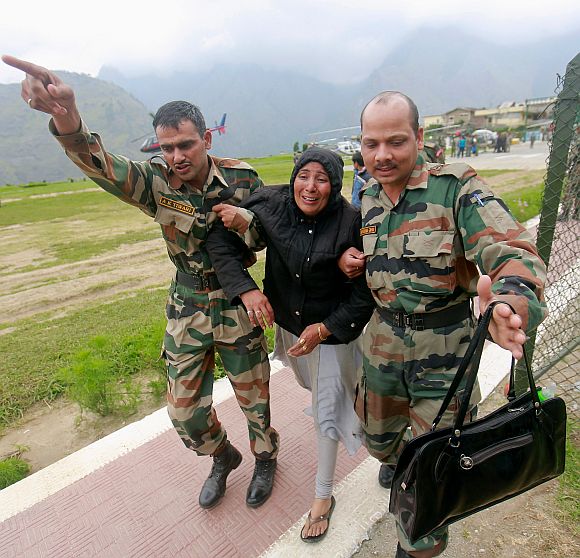 A woman cries in pain she is carried away by soldiers from an army helicopter during a rescue operation at Joshimath