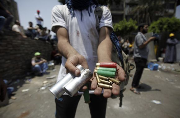 A member of the Muslim Brotherhood displays spent ammunition after clashes with army in front of Republican Guard headquarters