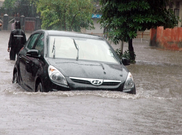 A vehicle makes its way through a flooded street in Mahim, Central Mumbai.