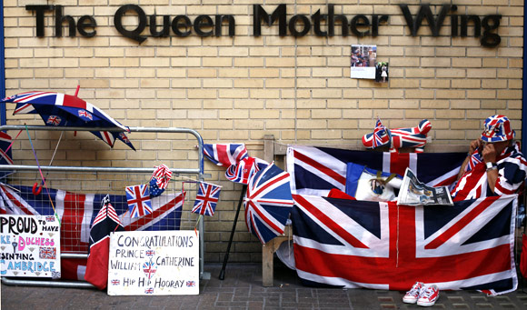 A Royal fan reads the newspaper outside St Mary's Hospital opposite the Lindo Wing