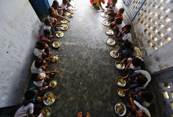 School children eat their free mid-day meal at a school in Bihar's Chapra district