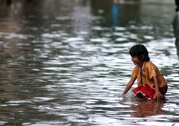 A child plays in the rain at Parel