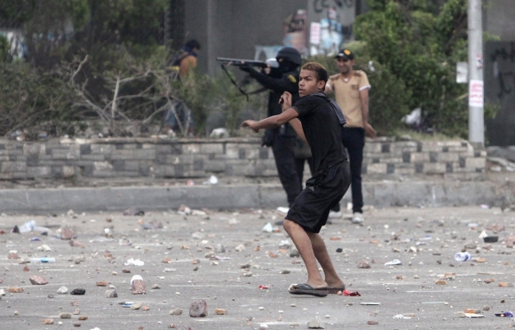 A police officer aims a shotgun at supporters of Morsi during clashes in Nasr city area, east of Cairo