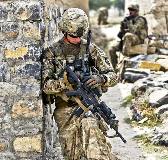 US Army Sgt. Eric Rothenberger checks his sights while pulling security at an alleyway in the village of Kunday